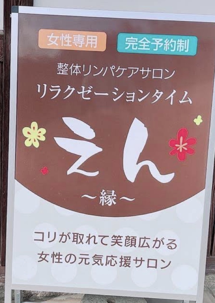 サロンの立て看板。整体リンパケアサロン リラクゼーションタイム えん〜縁〜と記された案内板